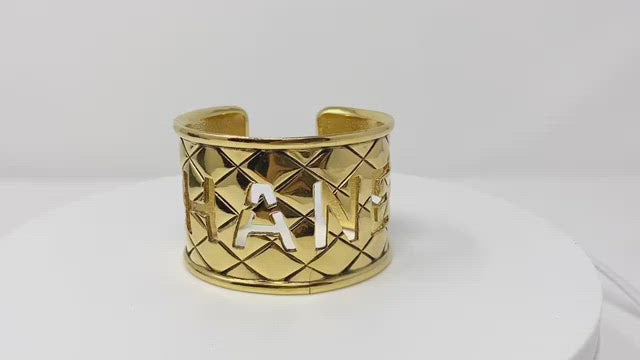 chanel gold bangle, quilted with logo cut-out.