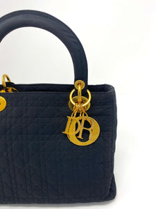 lady dior bag, black canvas, with Dior charms in gold.